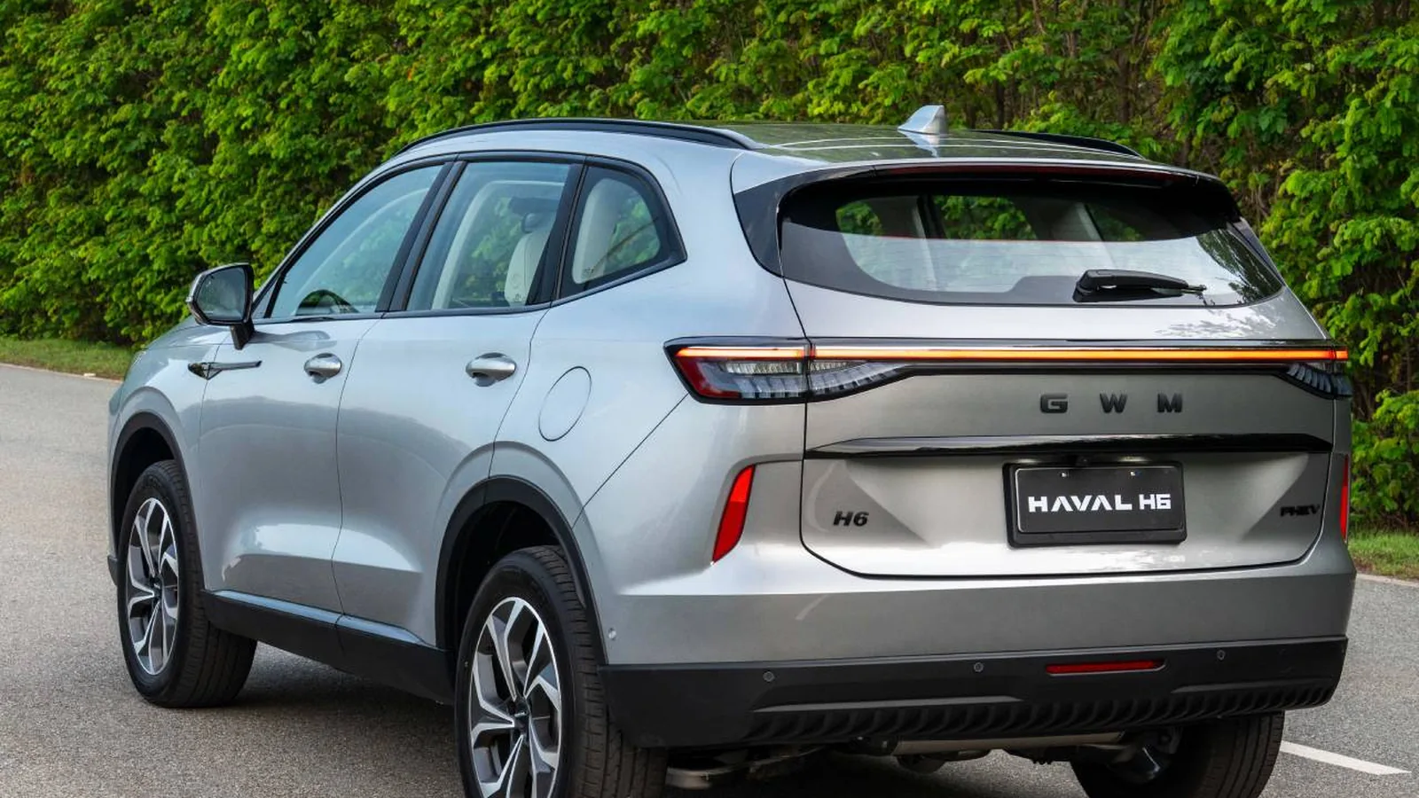 GWM Haval H6 cinza metálico vista lateral perfil em estrada