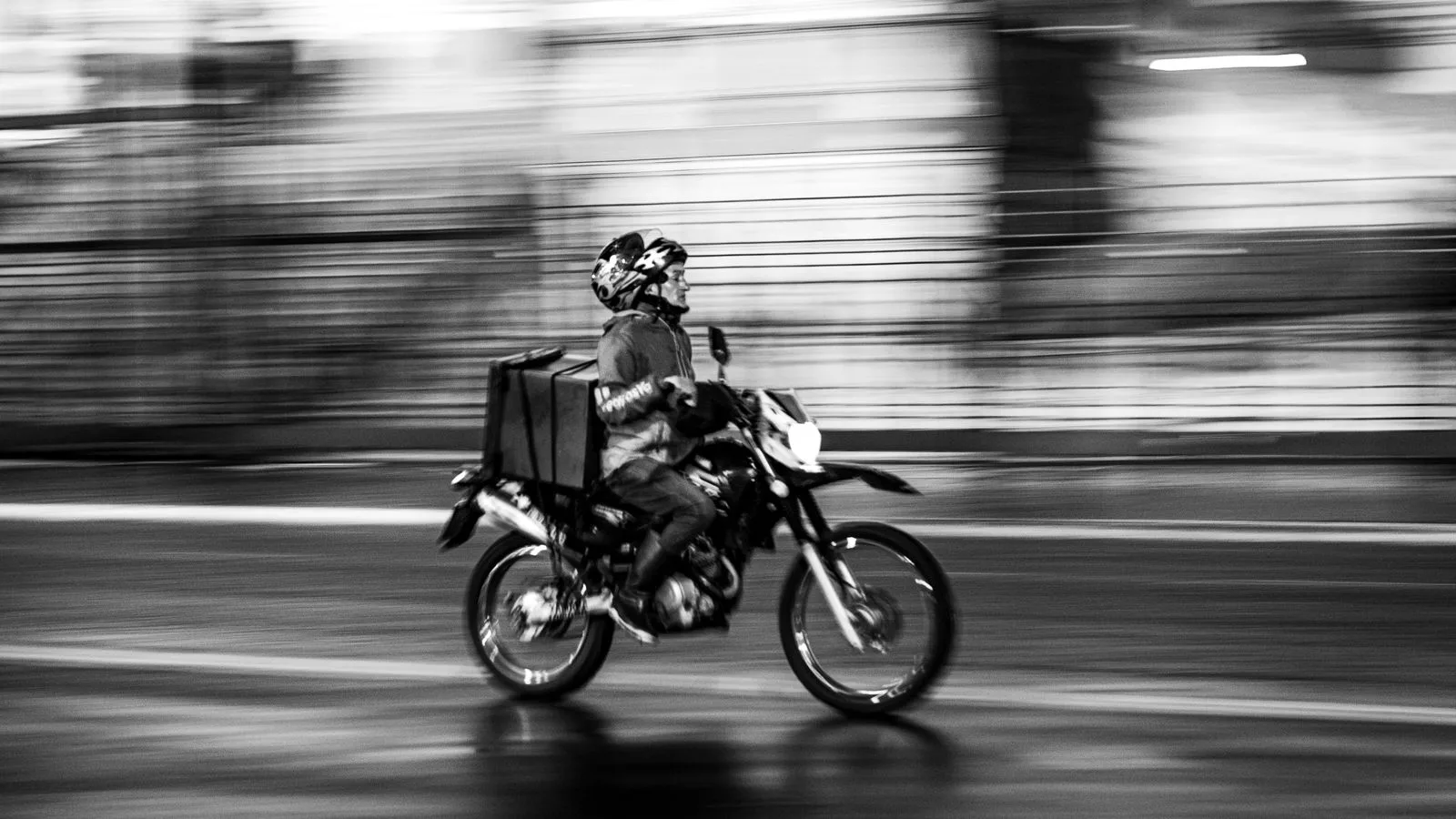 Long exposure shot of a delivery on a motorcycle in motion, Buenos Aires.