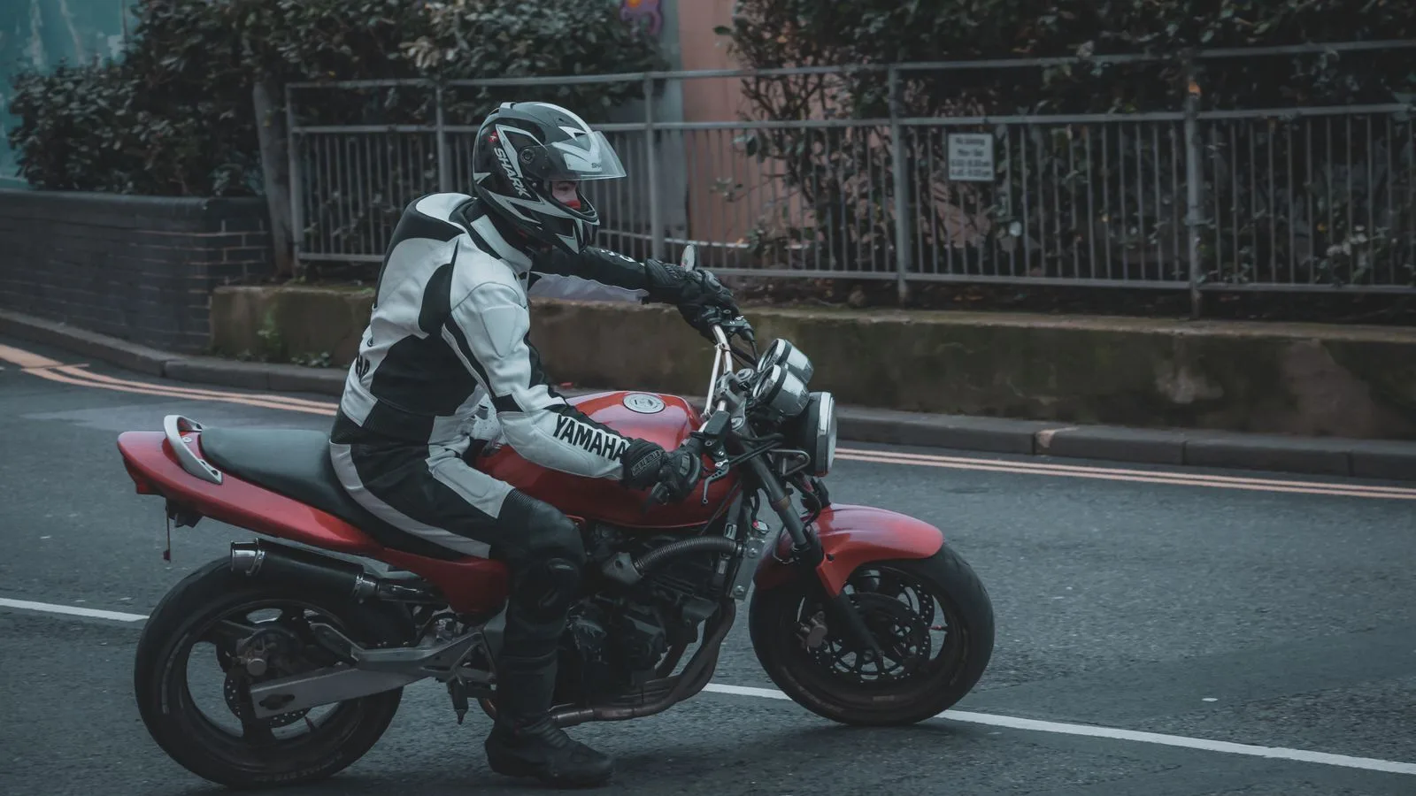A motorcyclist rides a red Yamaha on a street in Hastings, England.