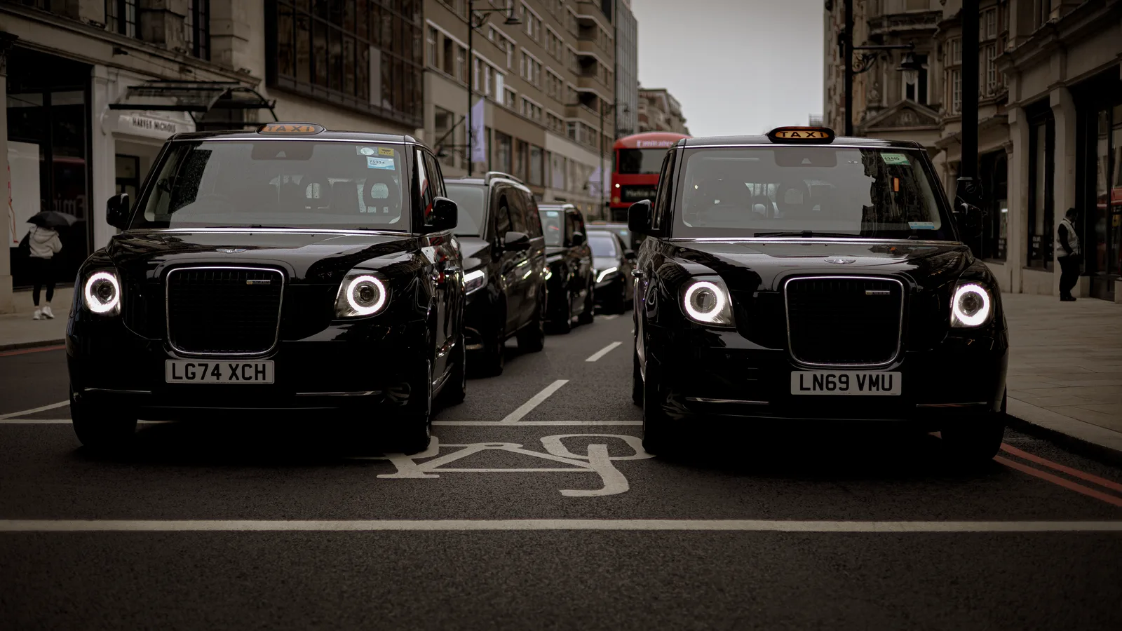 Black taxis line up on a London street showcasing modern urban transportation.
