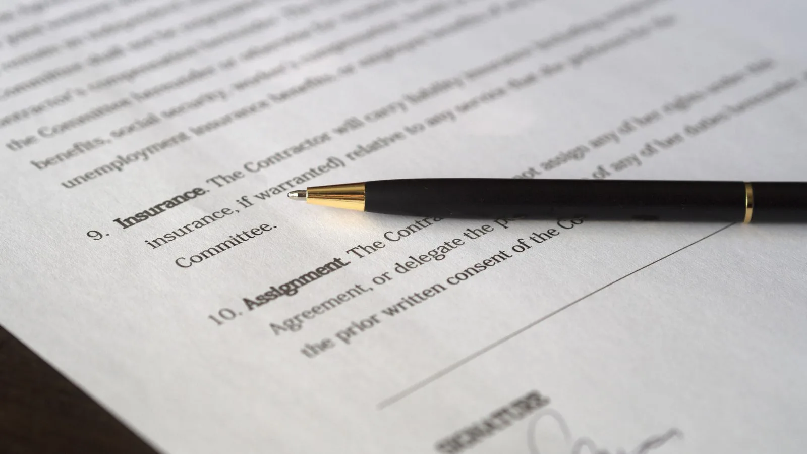 Close-up image of a business contract and pen, signed and ready for agreement.