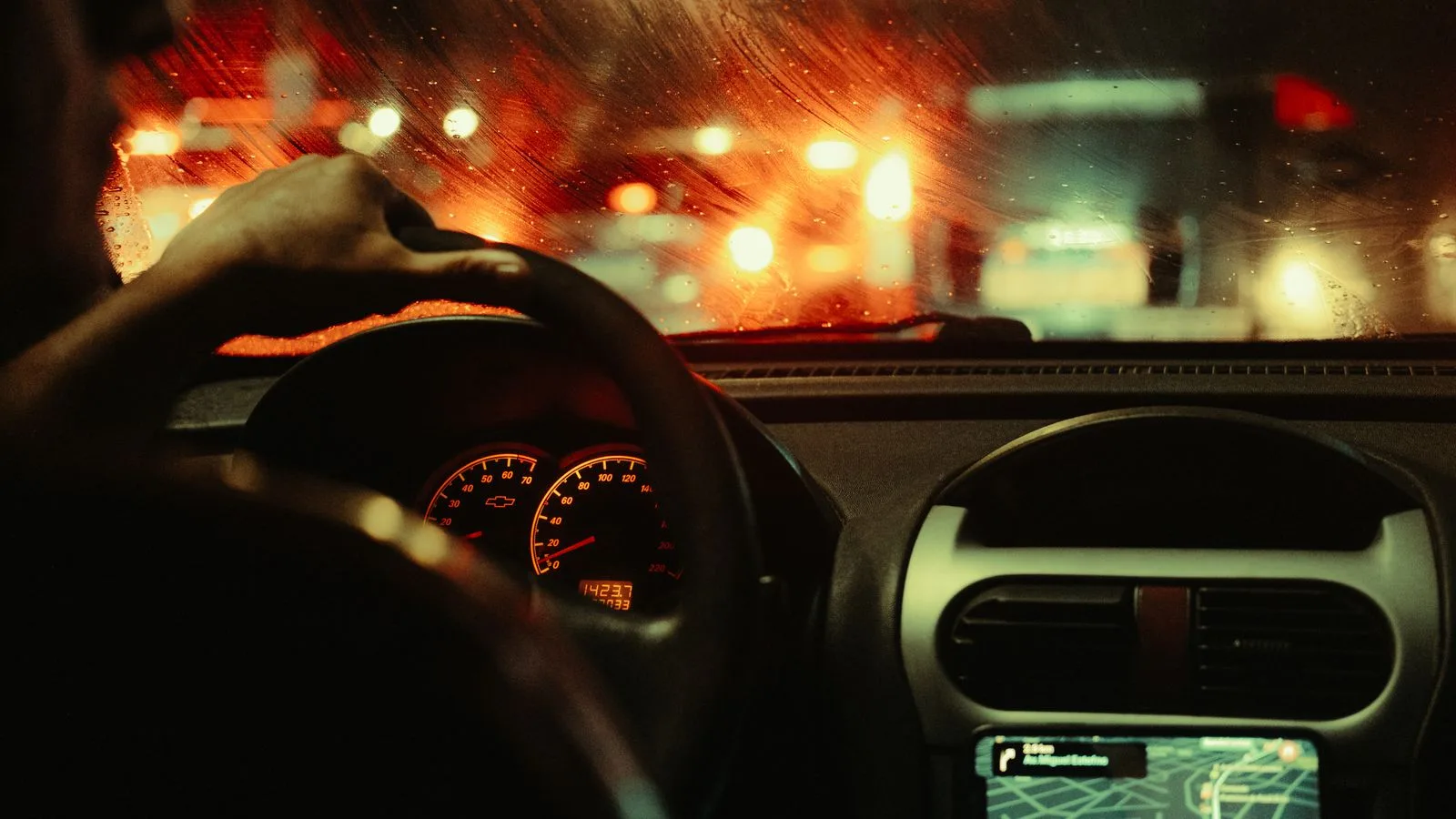 A man's perspective driving through São Paulo at night, focusing on city lights and traffic.