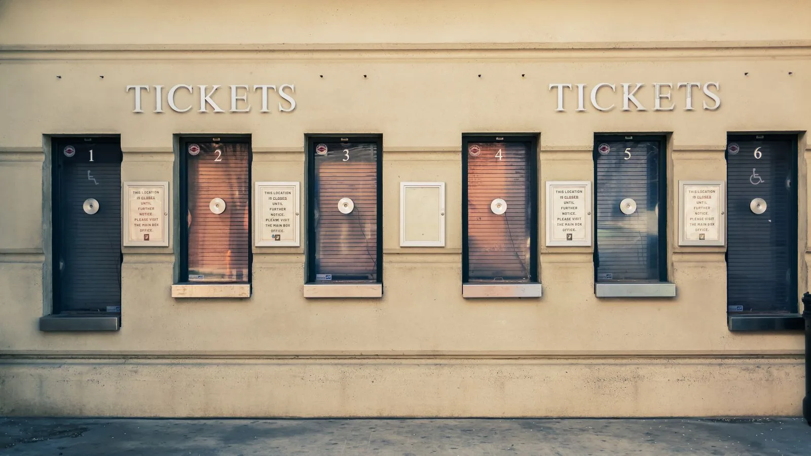 Row of closed ticket booths in Baltimore city center, showcasing urban architecture.