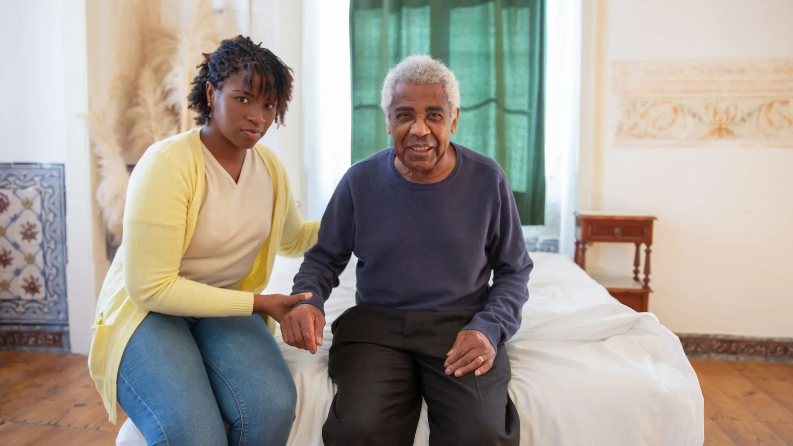 Daughter supporting elderly father in a bright, cozy room filled with love and warmth.