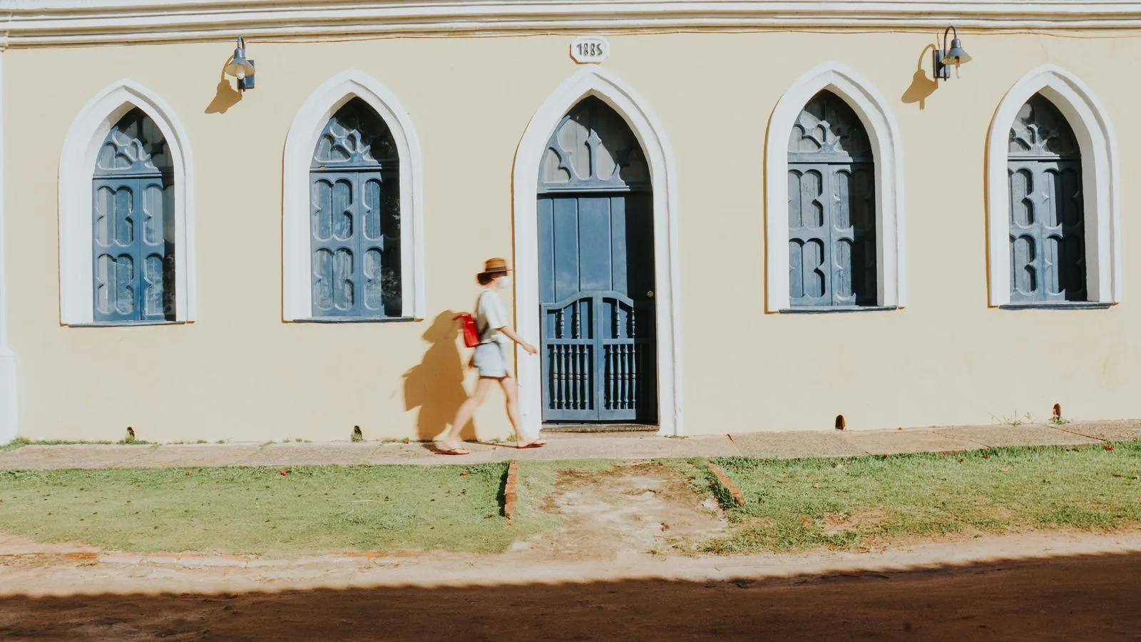 A person walks past a historic building in Porto Seguro, Bahia, Brazil during the day.