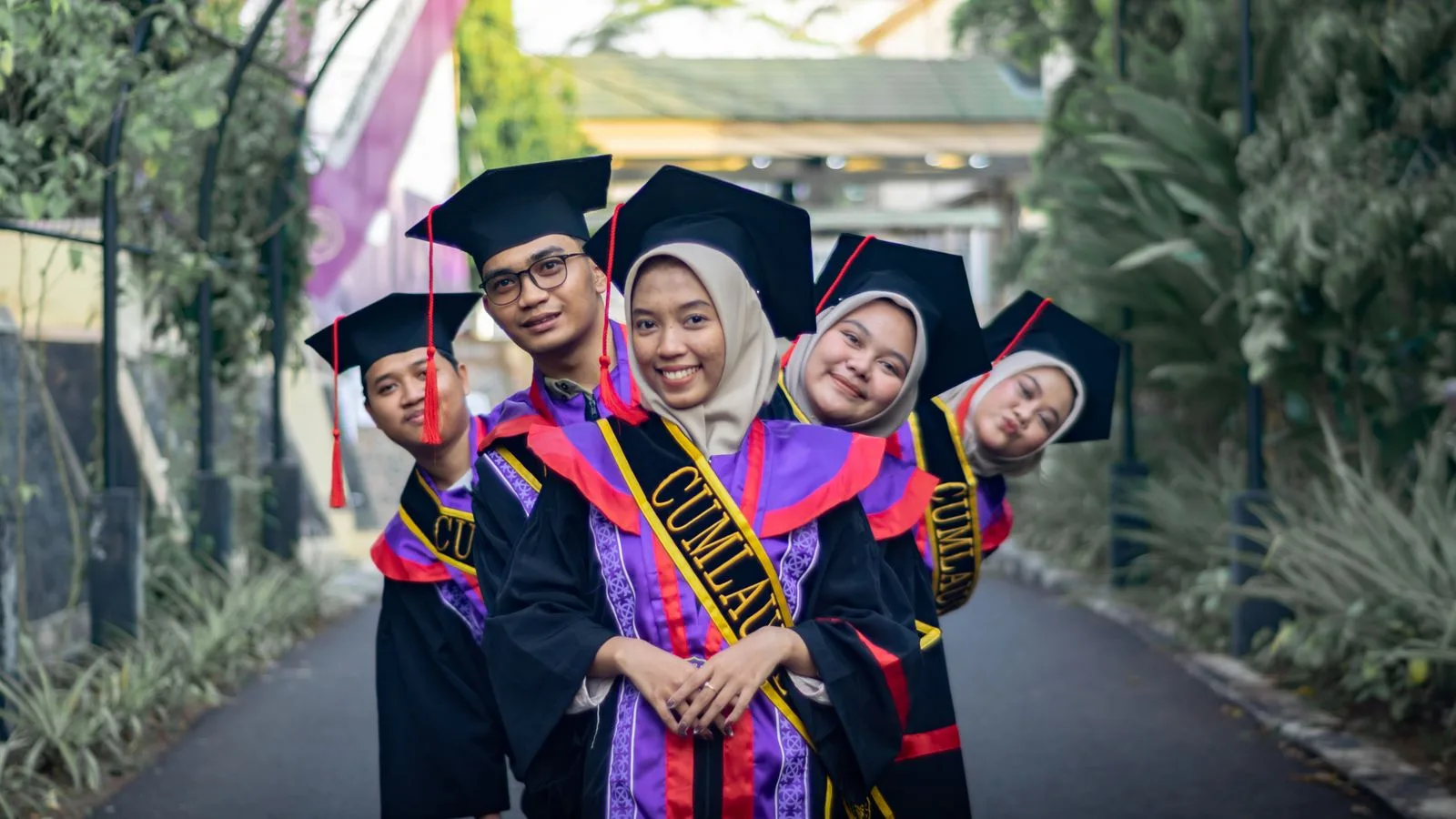 Joyful graduates in caps and gowns celebrating their success outdoors.