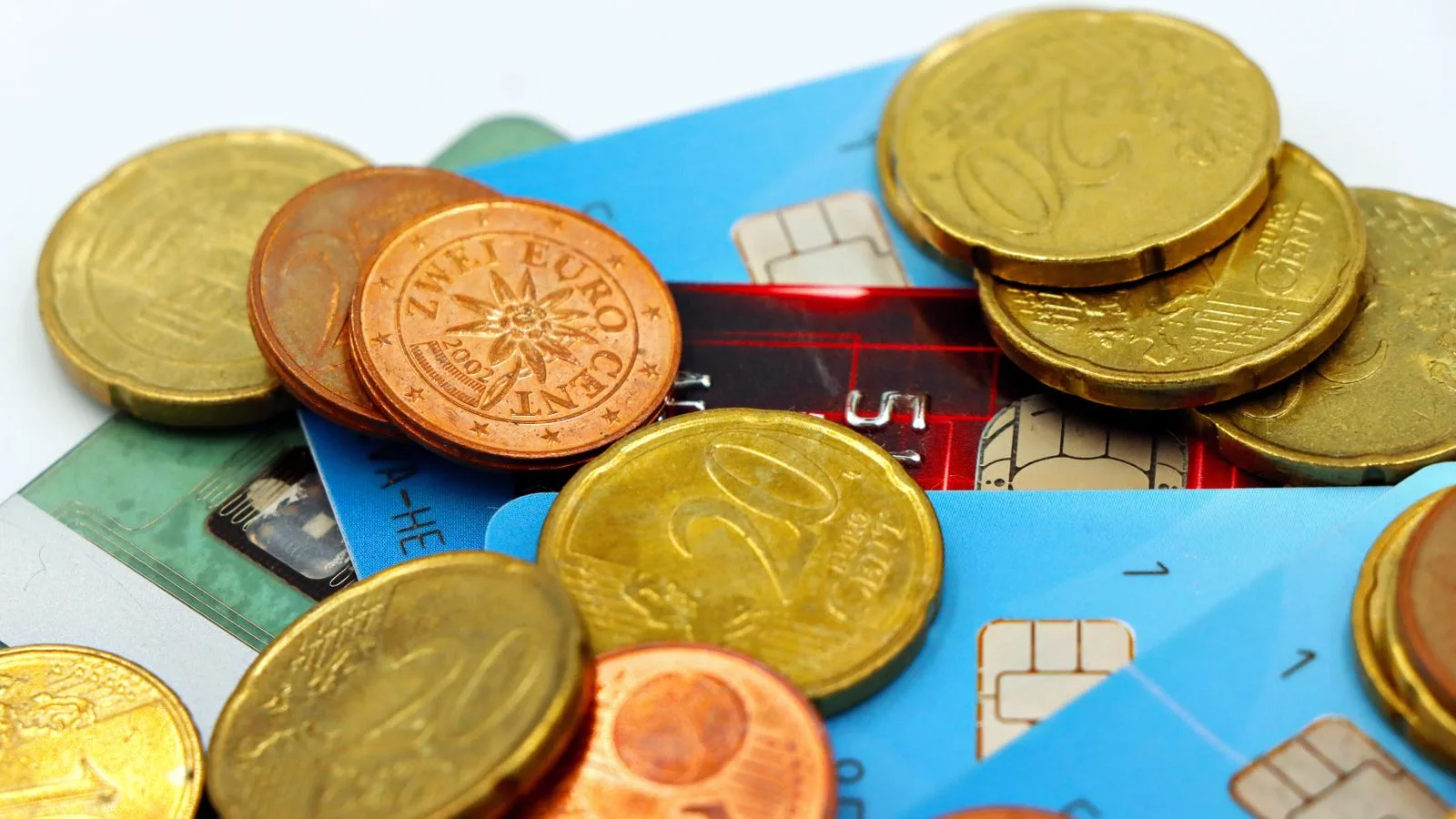 Close-up image of Euro coins and credit cards representing modern financial transactions.