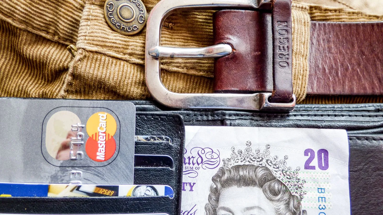 A detailed image of a wallet containing credit cards, a leather belt, and currency, emphasizing personal finance.