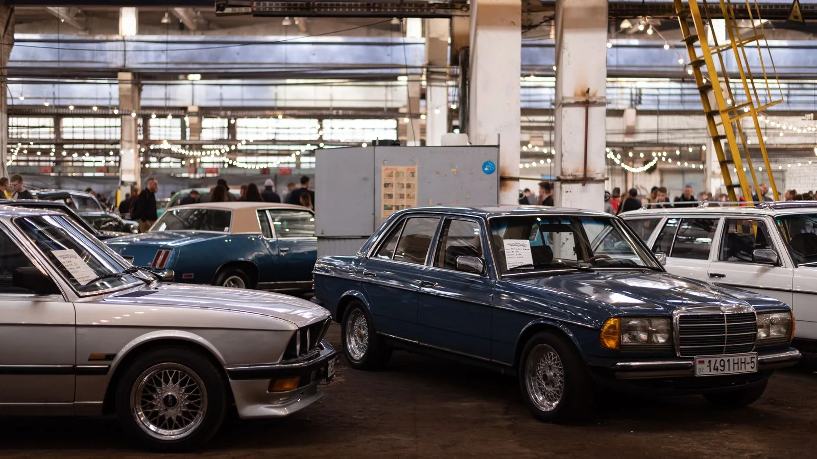 A collection of vintage cars showcased at an indoor car show, capturing classic automotive elegance.