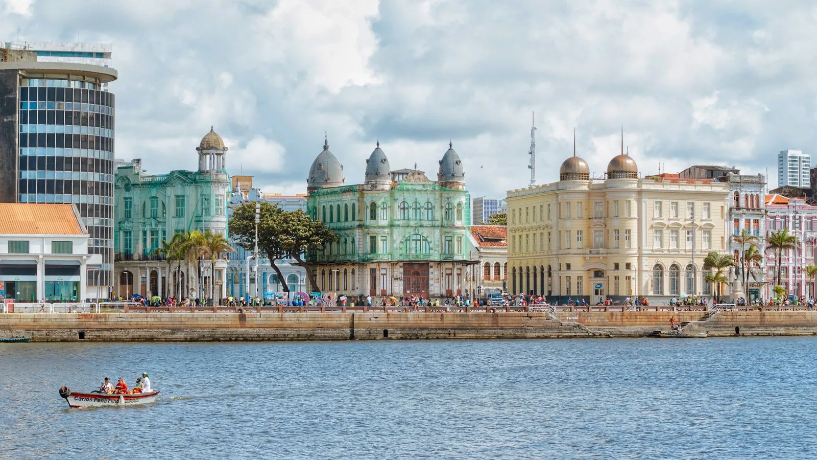 Vibrant cityscape of Recife's historic waterfront buildings under a cloudy sky.