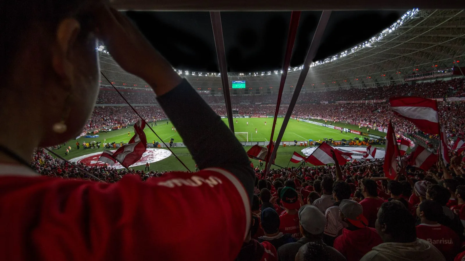 Lively soccer match at packed Brazilian stadium with cheering fans and vibrant atmosphere.