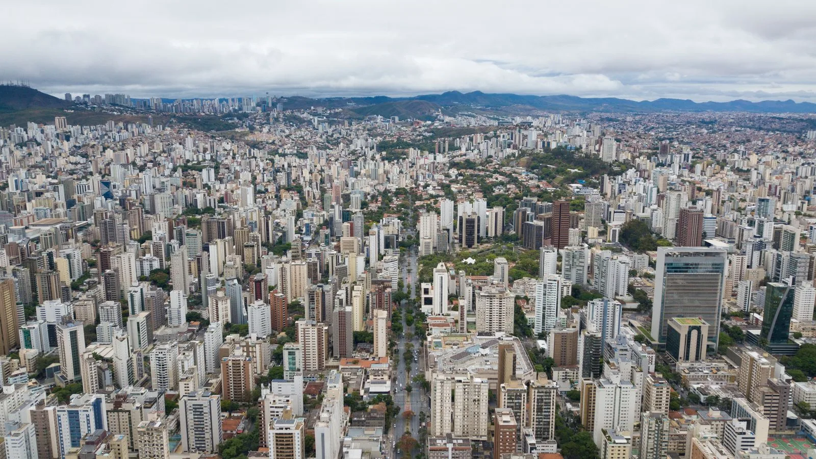 Panoramic aerial view of Belo Horizonte's sprawling urban landscape, showcasing high-rise buildings and residential areas.