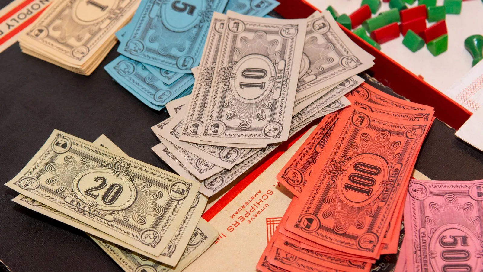 Colorful Monopoly money and game pieces arranged on a game board for a classic board game night.