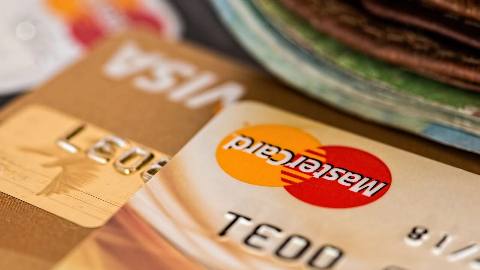 Macro shot of credit cards showing Visa and Mastercard logos next to a wallet, ideal for finance themes.