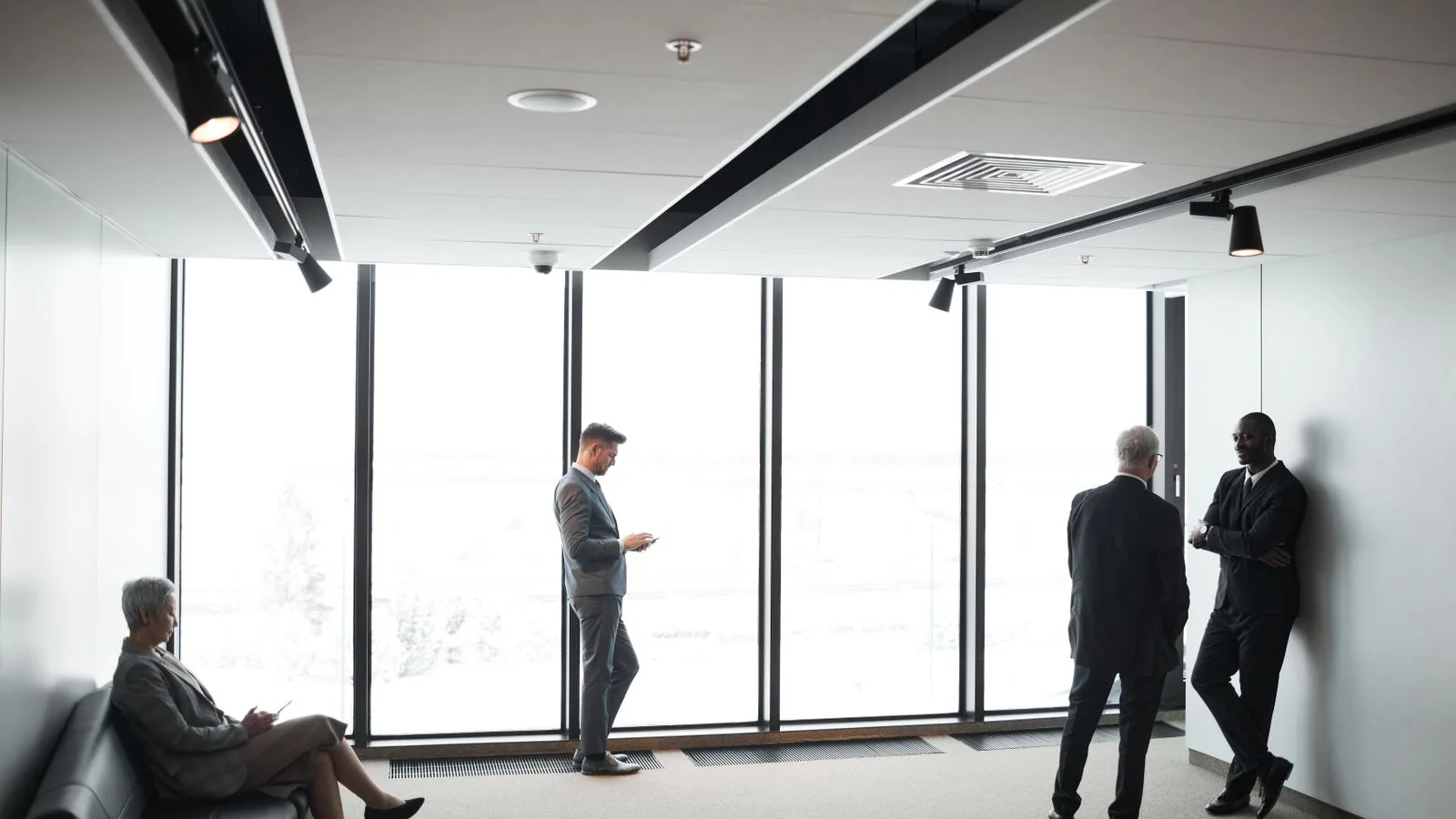 Diverse business professionals interacting in a bright, modern office setting.