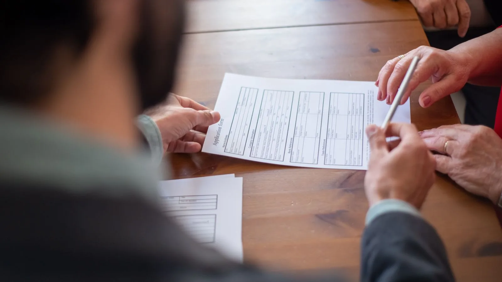Close-up of business professionals reviewing documents at a meeting.