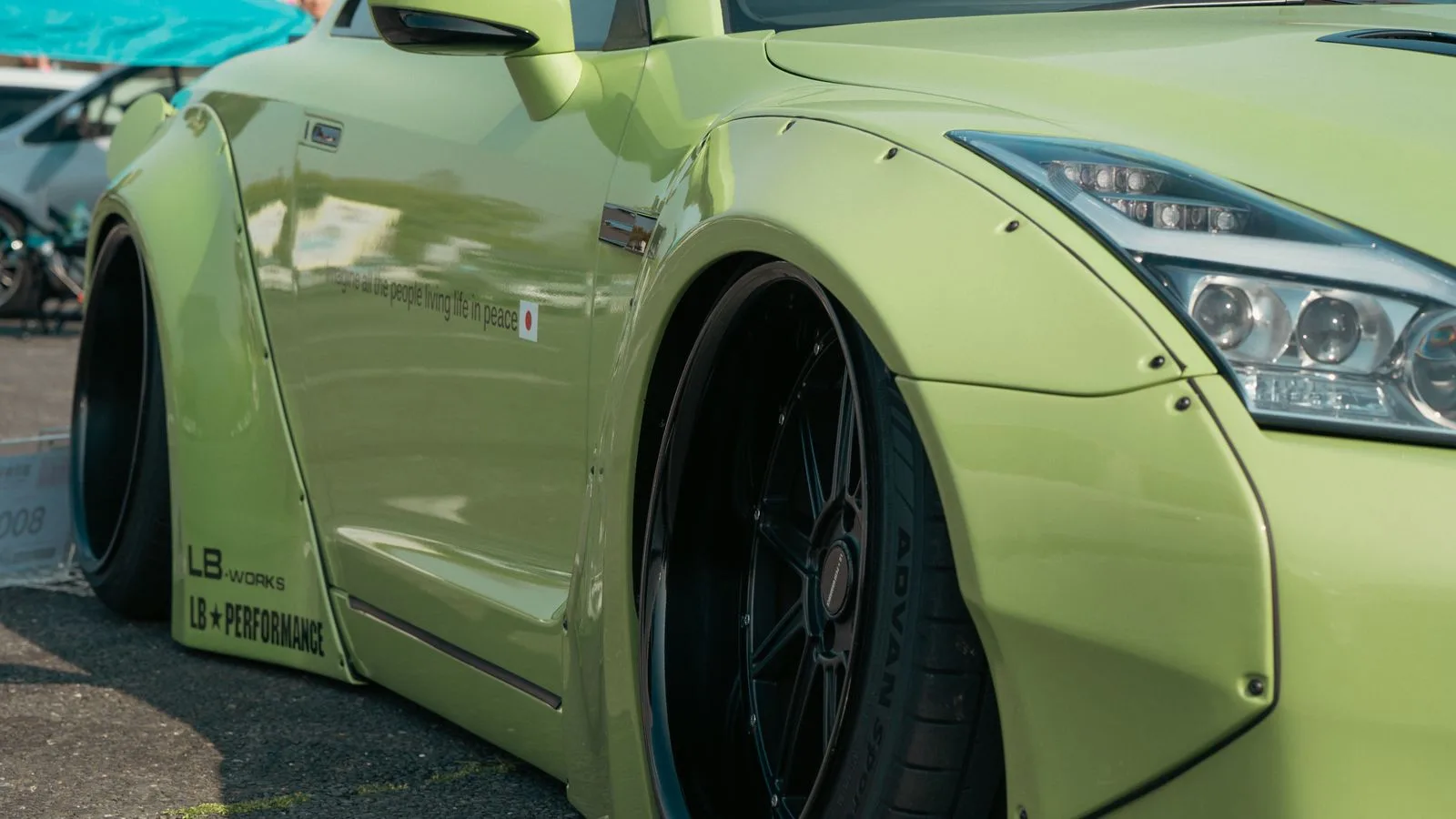 Detailed view of a neon green custom car in an outdoor Tokyo car show.