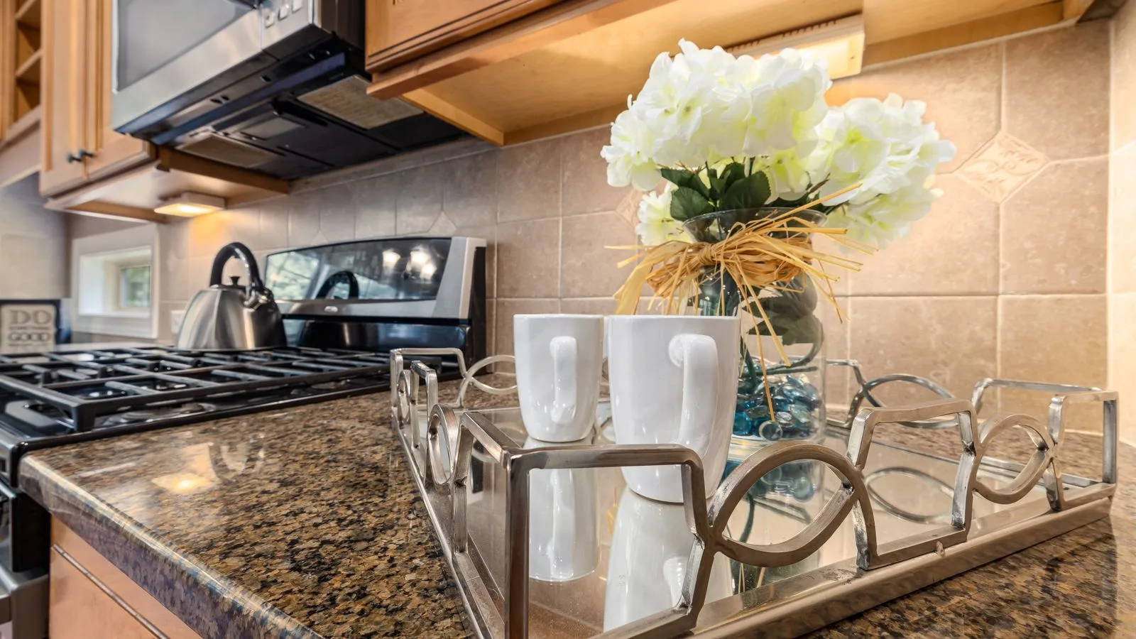 Contemporary kitchen with granite countertops, stainless steel appliances, and decorative elements.