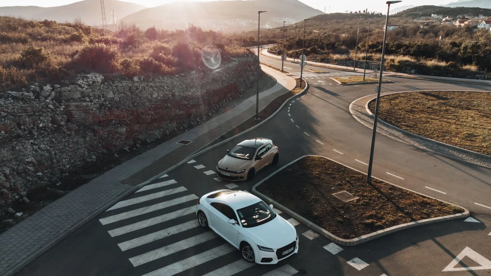 Aerial shot of cars on a road at sunset in Tivat, Montenegro. Scenic landscape and quiet urban scene.