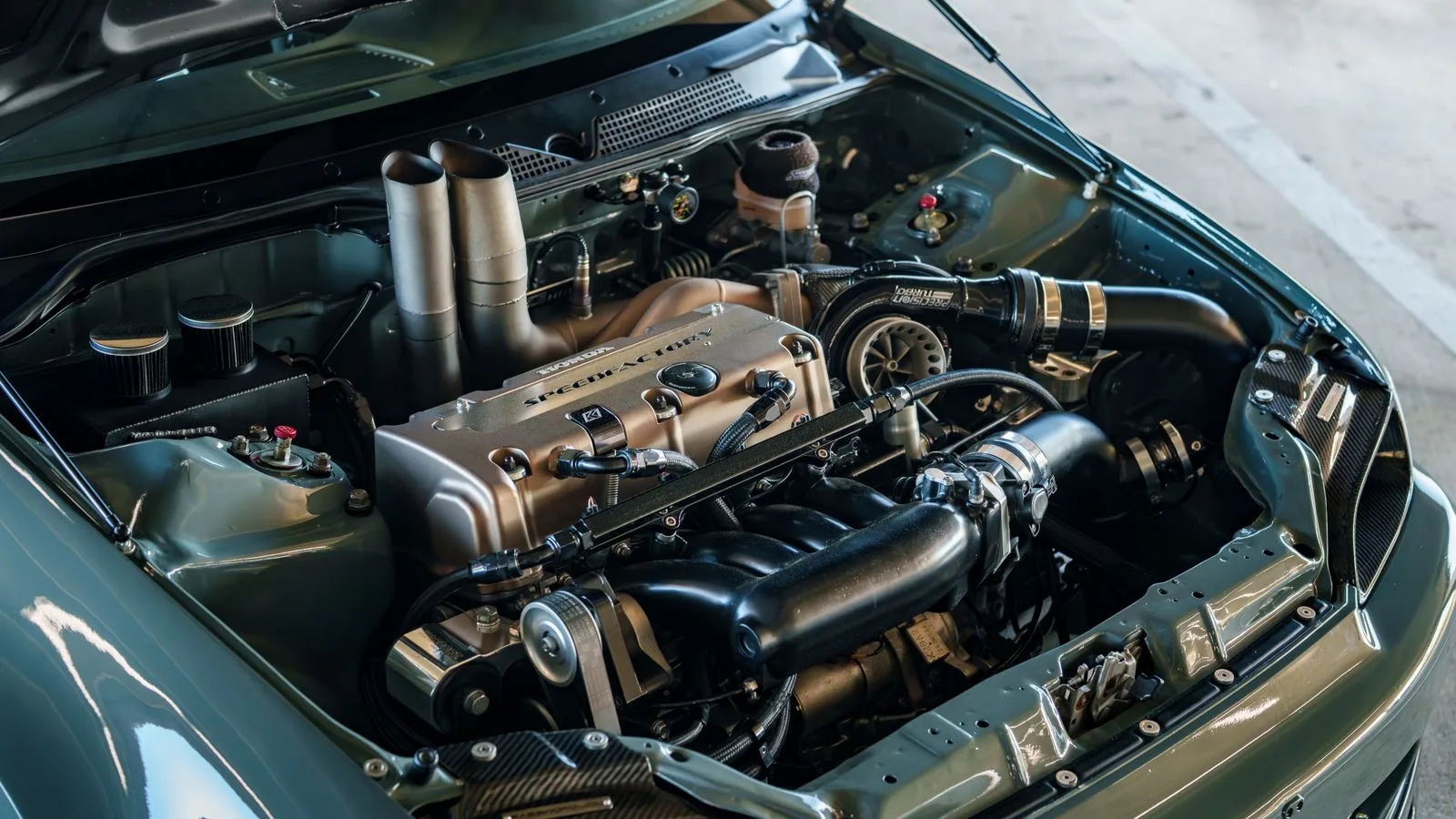 Close-up of a modified car engine with a turbocharger showcasing advanced performance parts.