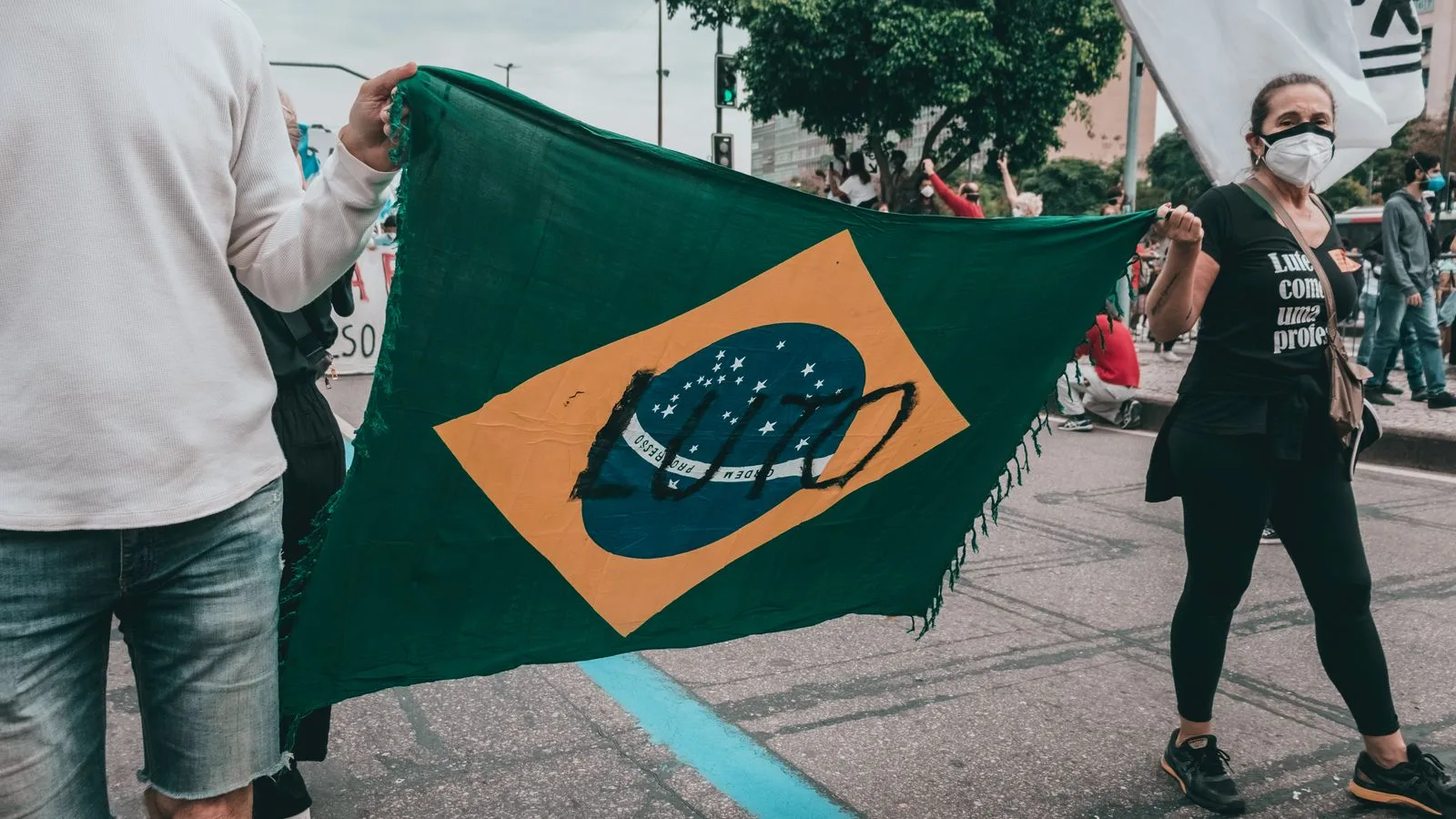 A group of protesters in Rio de Janeiro holding a Brazilian flag during a demonstration.