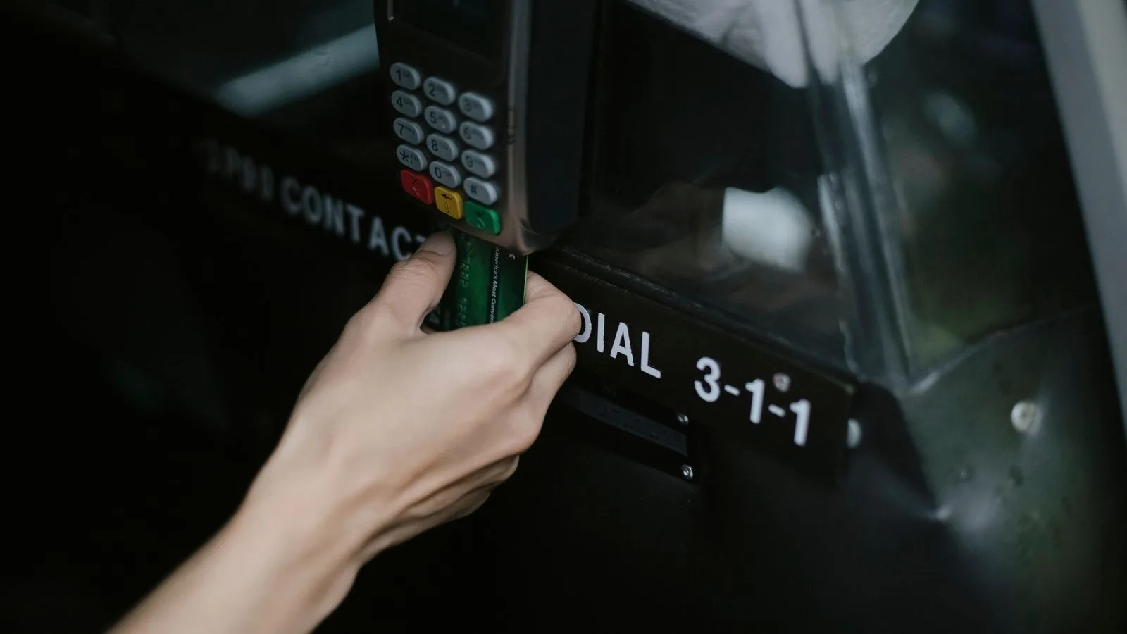 Crop anonymous traveler using card device while paying for taxi ride in automobile