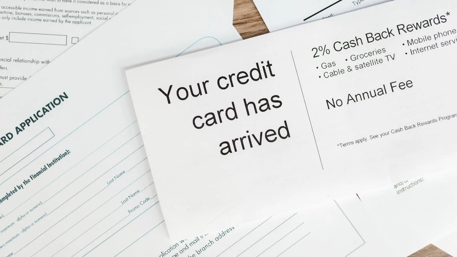 Close-up of a letter announcing the arrival of a credit card amidst financial documents.