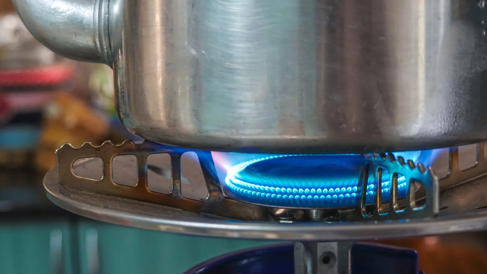 A detailed image showing a gas stove burner with a pot above, highlighting kitchen heat and flame.
